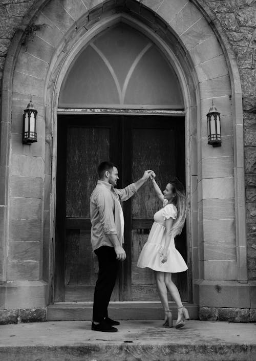 A couple dancing in front of a church