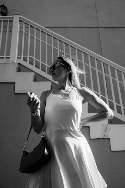 A woman in a white dress is standing on the stairs