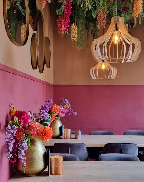 A restaurant with pink walls and hanging flowers