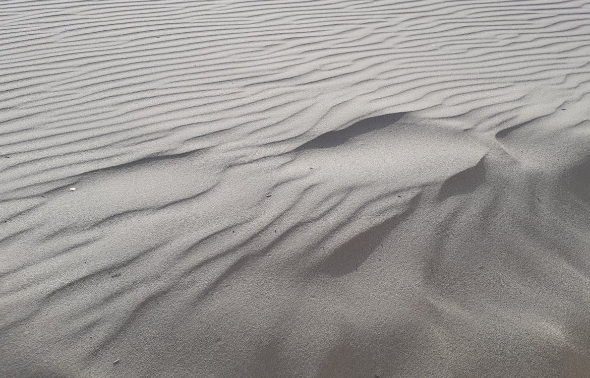 Sand dunes in the desert with a white background