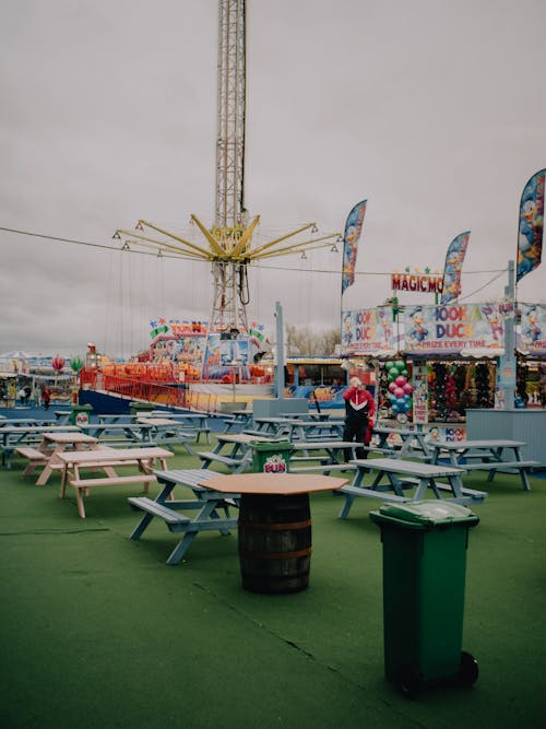 A carnival ride and tables and chairs in a field