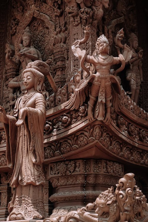 A statue of a woman and a man in front of a temple