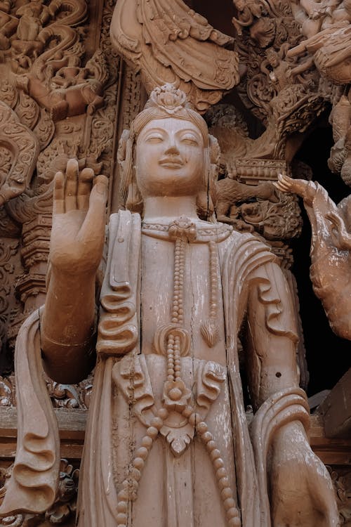 A statue of a buddha with hands raised