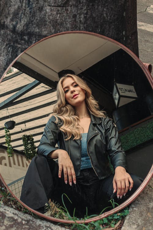 A woman sitting in a round mirror