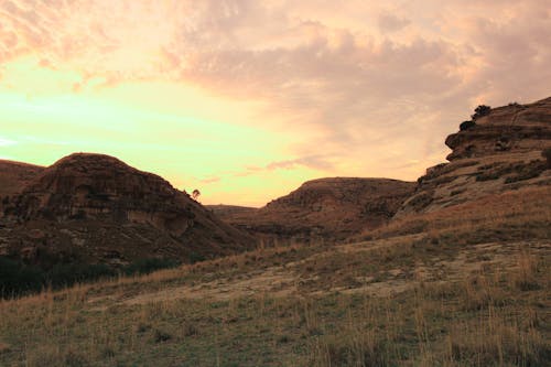 Grassy hill with mountains in the background at dusk