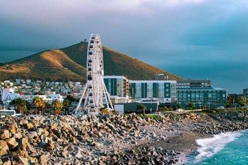A ferris wheel and a beach in front of a mountain