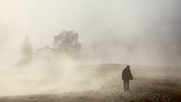Person walking in misty countryside of Lungern, Switzerland, evoking mystery and solitude.