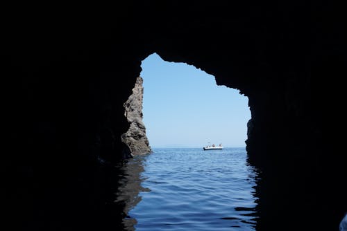 People on Motorboat near Cave on Sea Shore