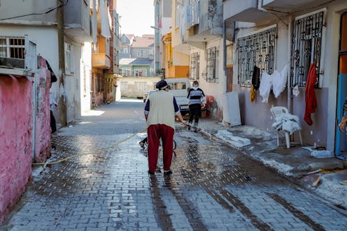 Women wash the streets with hoses in the Gypsy neighborhood