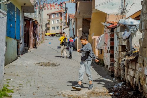 Free Children playing on a sunlit street in Tekirdağ city, Türkiye, showcasing urban life. Stock Photo