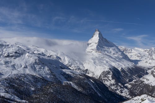 The matterhorn mountain is seen from the top of a snowy mountain