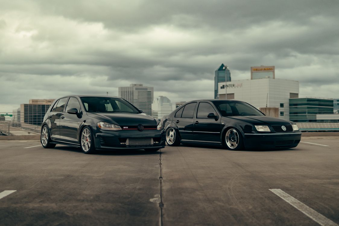 Two Cars Backround Two Volkswagen Cars Against the Cityscape Background · Free Stock Photo