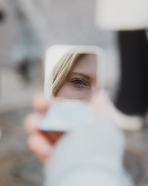 A woman is looking at herself in a mirror