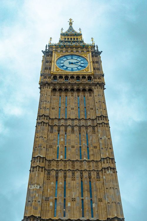 Free Stunning upward view of London's Big Ben with gothic architecture and a cloudy sky backdrop. Stock Photo