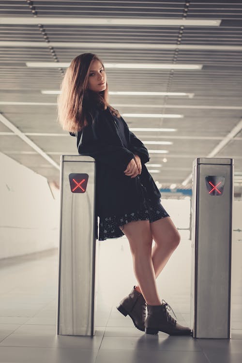 Woman Leaning on Gray Stainless Steel Panel