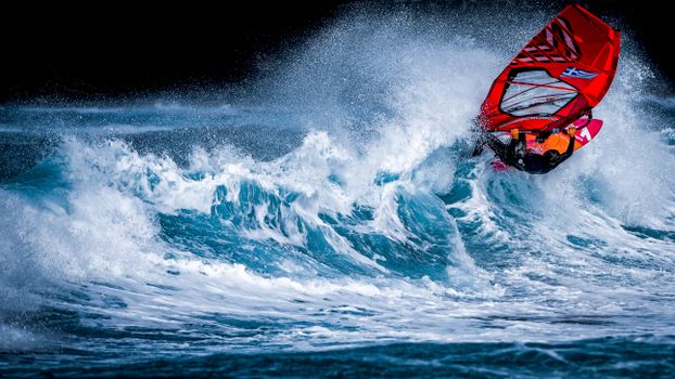 Dynamic windsurfing scene with vibrant colors and thrilling motion on ocean waves.