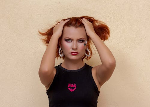 A woman with red hair is posing for a photo