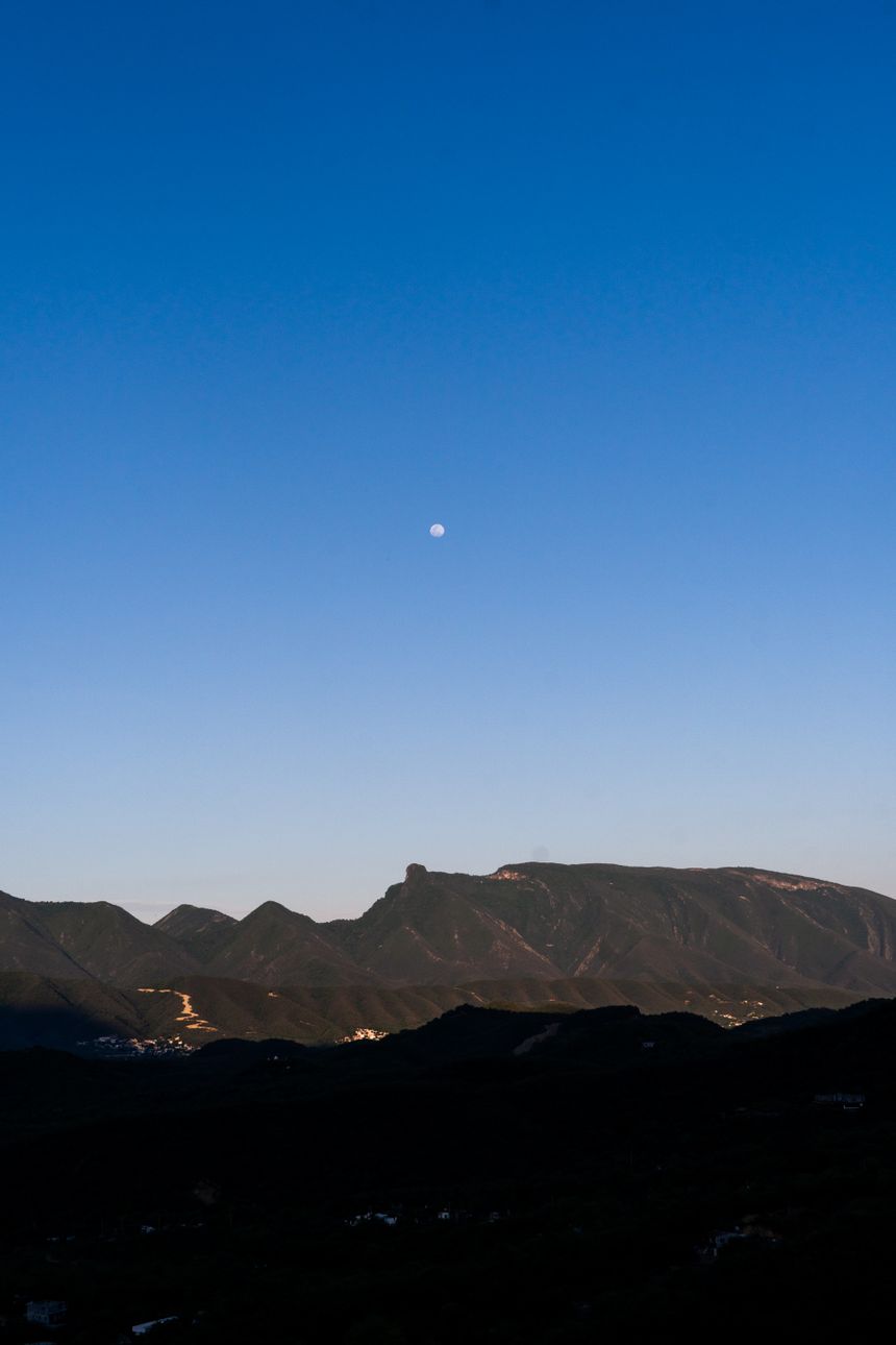 Moonrise over a dark mountain ridge at dusk — photo by Deniss Bojanini on Pexels