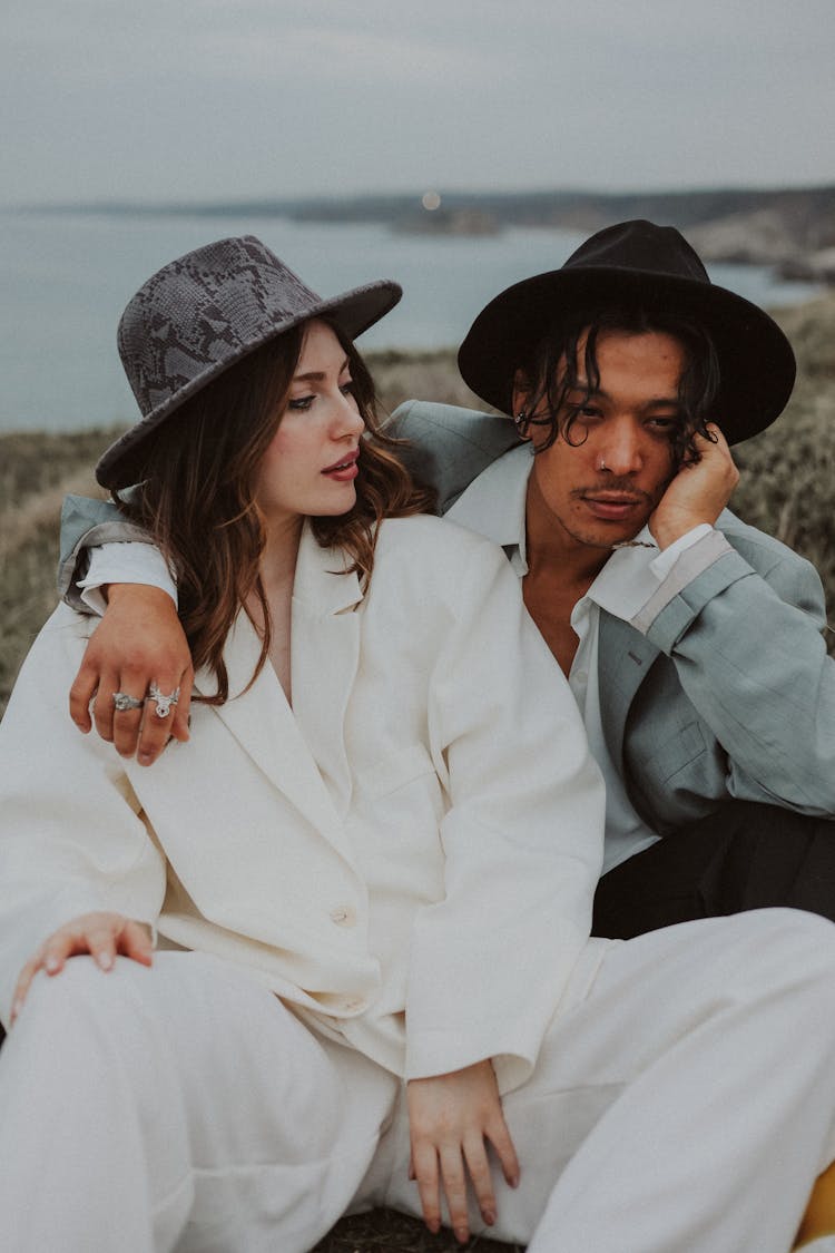 Fashionable Man And Woman Sitting Outside 