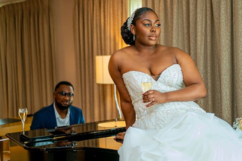 Bride with a Glass of Champagne Sitting on a Piano