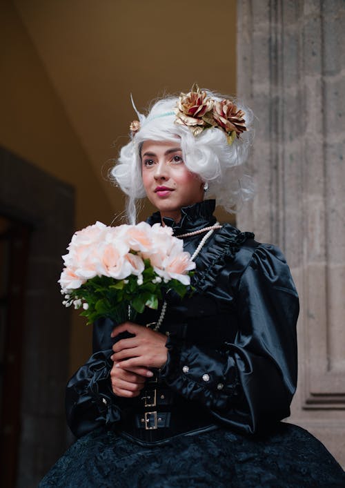 A woman in a black dress holding a bouquet