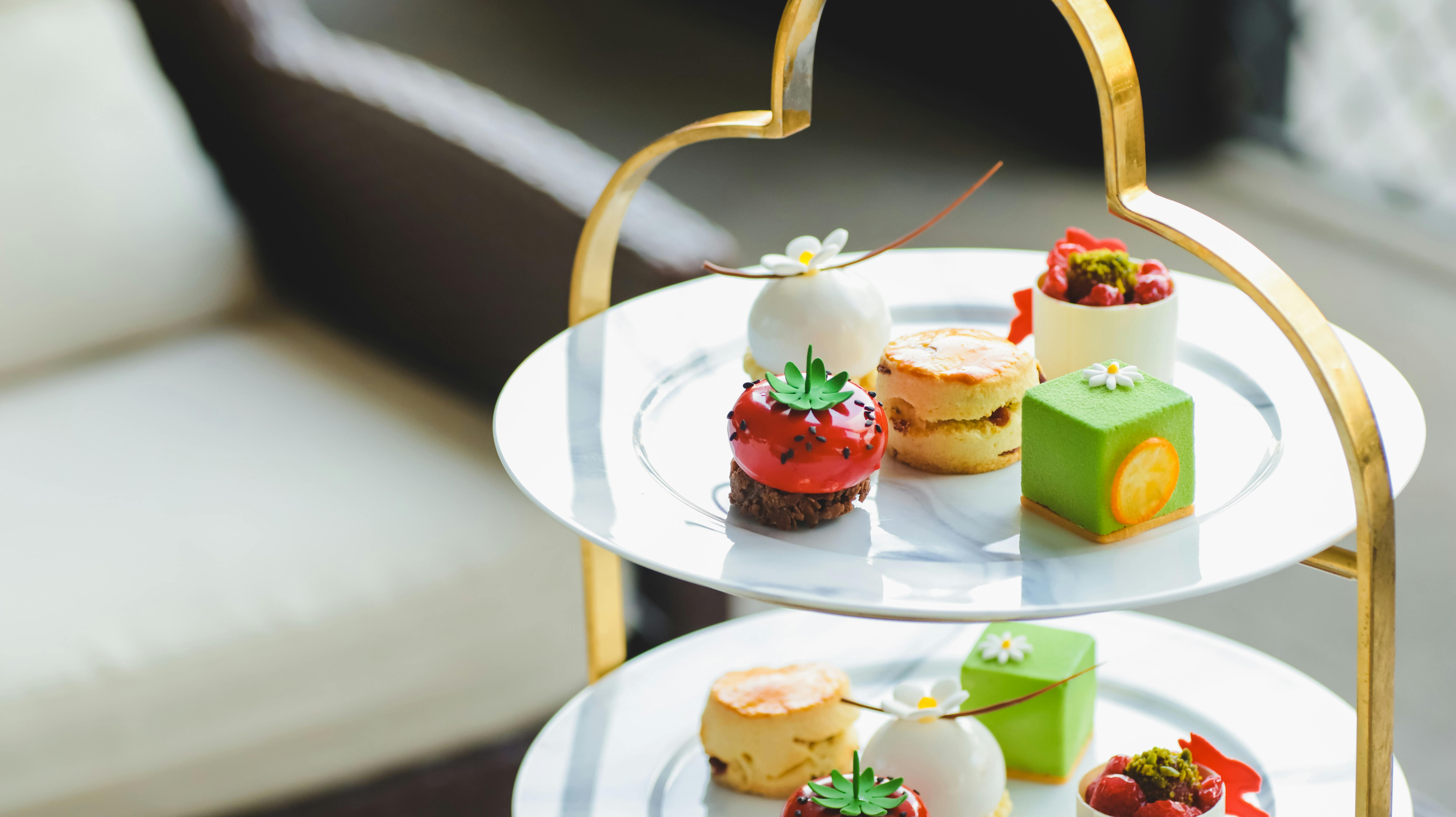 Close-up of a stylish high tea stand showcasing colorful gourmet desserts in natural light.