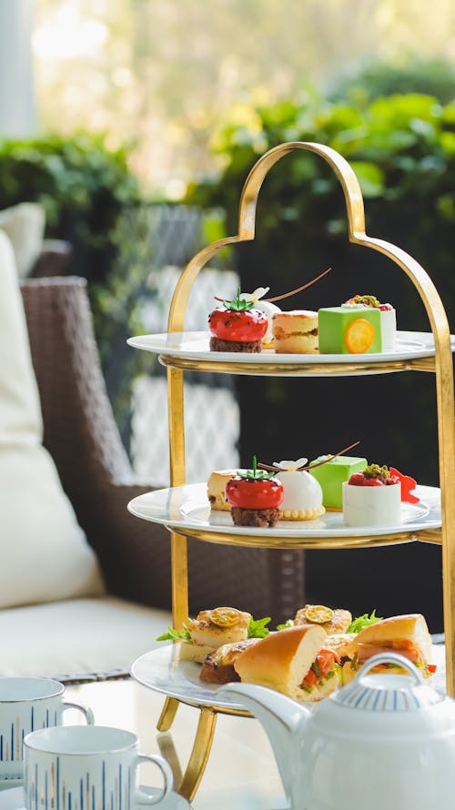 A three tiered tray with tea and pastries