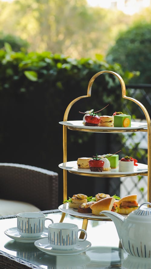 A three tiered tray with tea and pastries