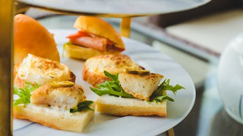 A plate with sandwiches and tea on it