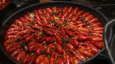 A tantalizing dish of spicy cooked crawfish garnished with vegetables.