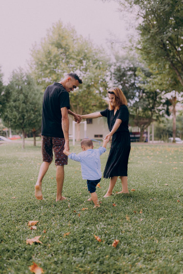 Parents Playing With Their Child In A Park