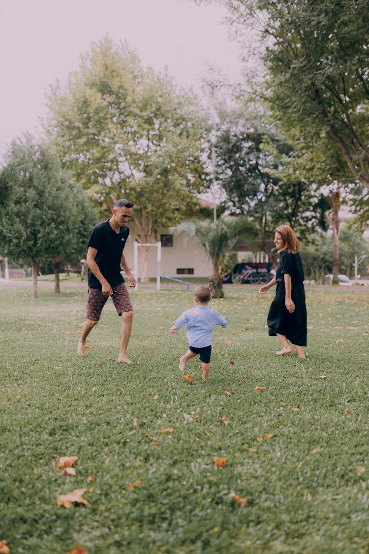 Parents Playing With Their Child In A Park