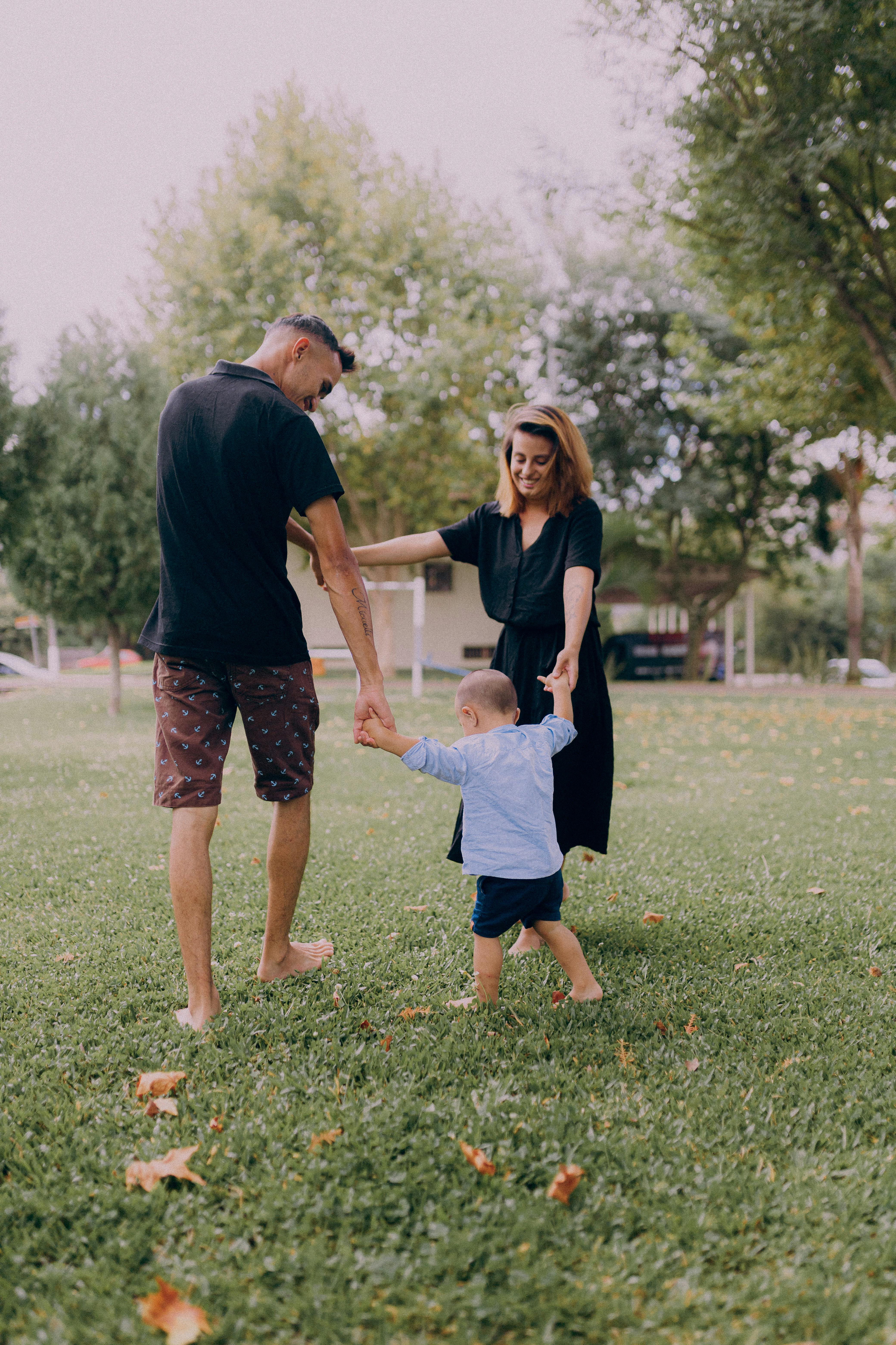 parents playing with their child in a park