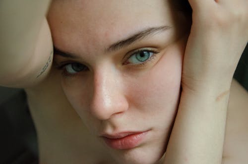 A woman with blue eyes and a tattoo on her arm