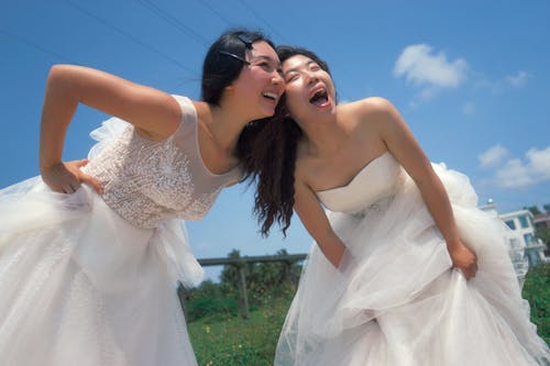 Women in White Wedding Dresses Laughing