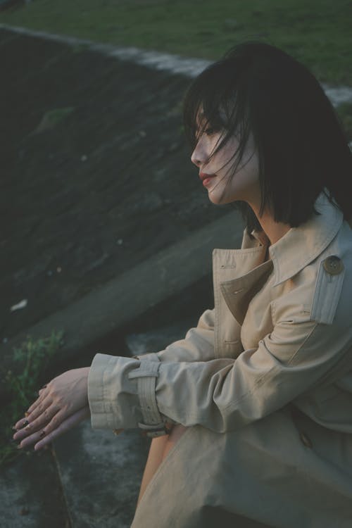 A woman sitting on the ground with her hands on her knees