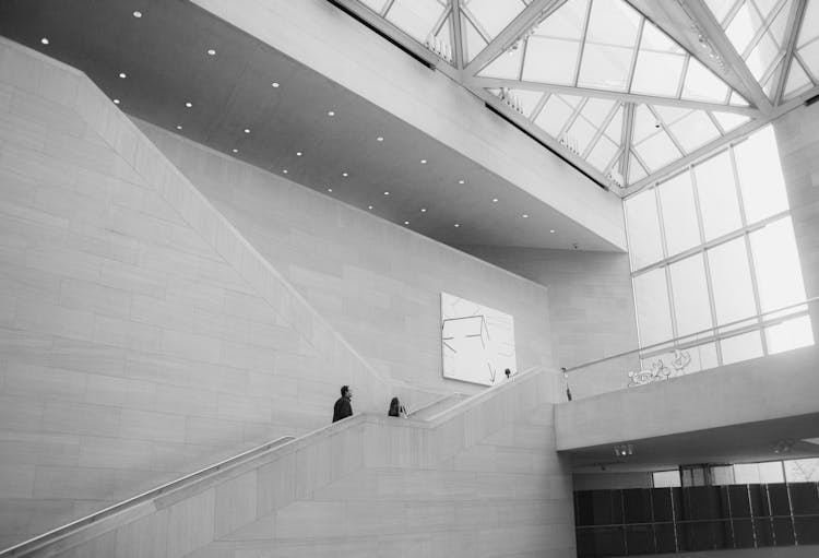 Two Person Walking On Stairs Inside Building