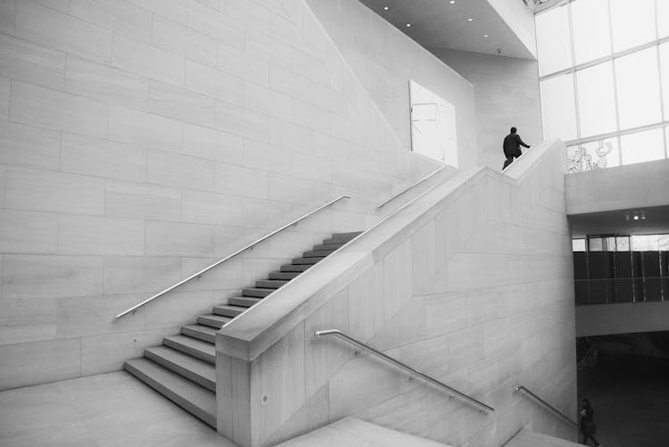 Person Walking Up Stairs Grayscale Photo