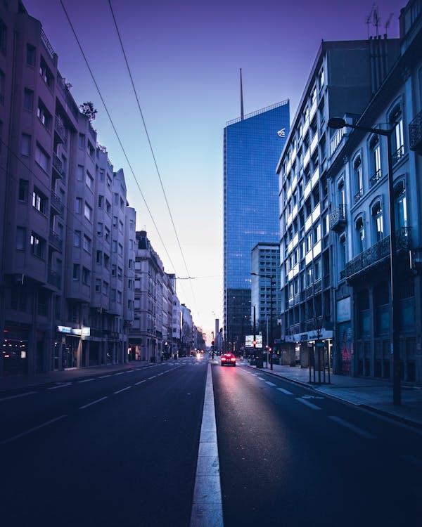 Car on Road Near Concrete Buildings