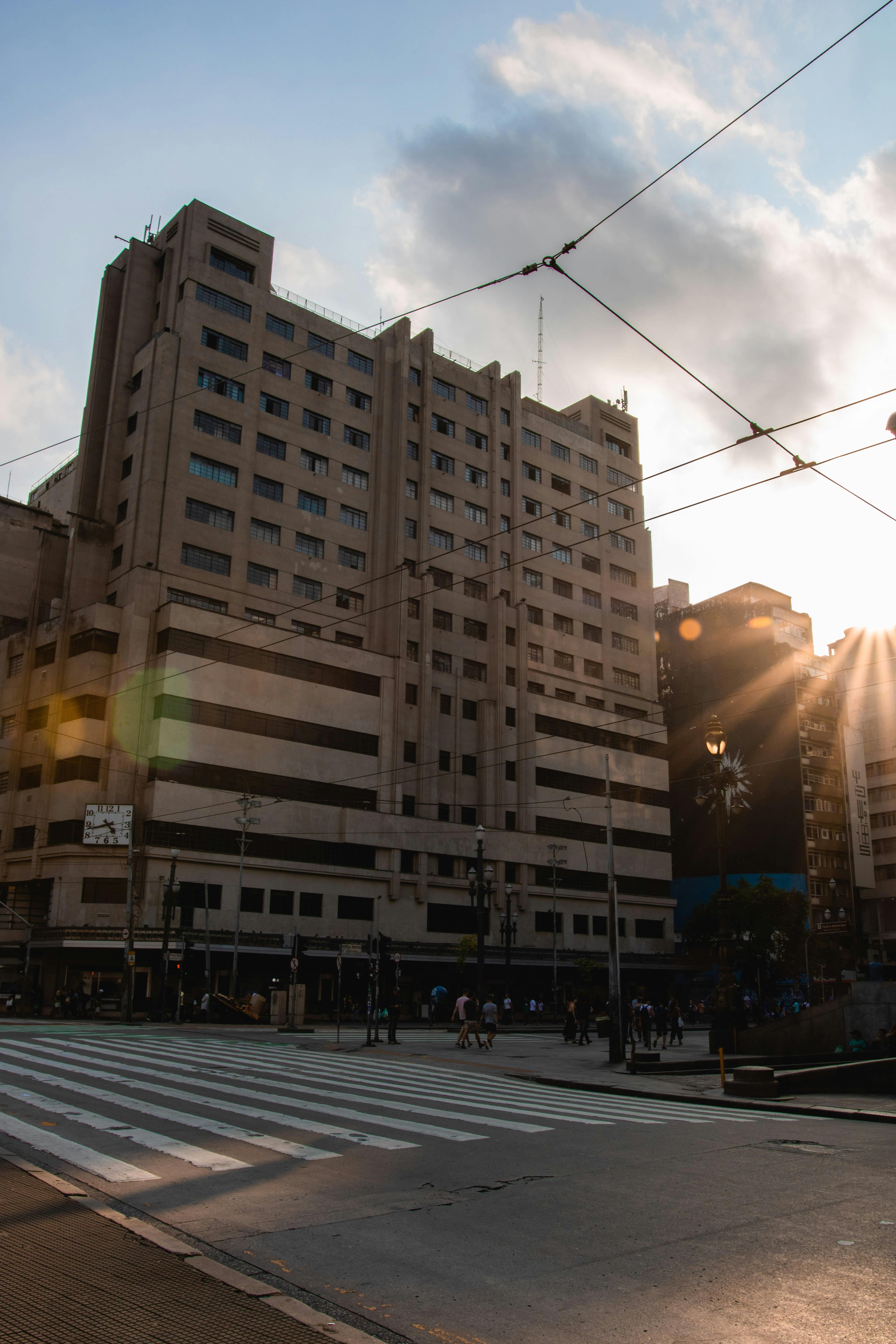 日落时分，高层建筑旁的人行横道捕捉到了戏剧性云层下的城市生活