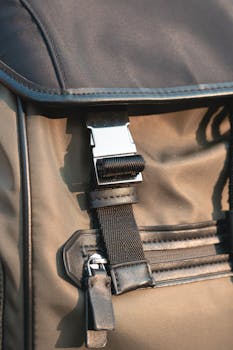 Close-up of a stylish nylon backpack featuring a metal buckle and zipper pocket detail.