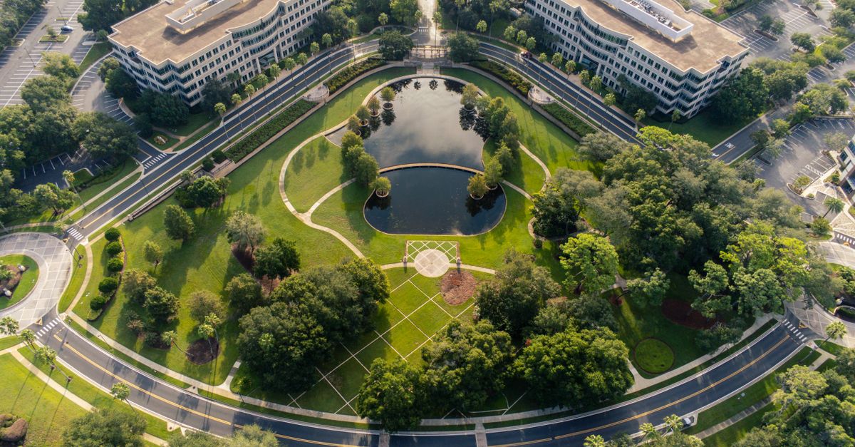 Drone shot of office complex and landscaped park with a pond in Lake Mary, Florida.