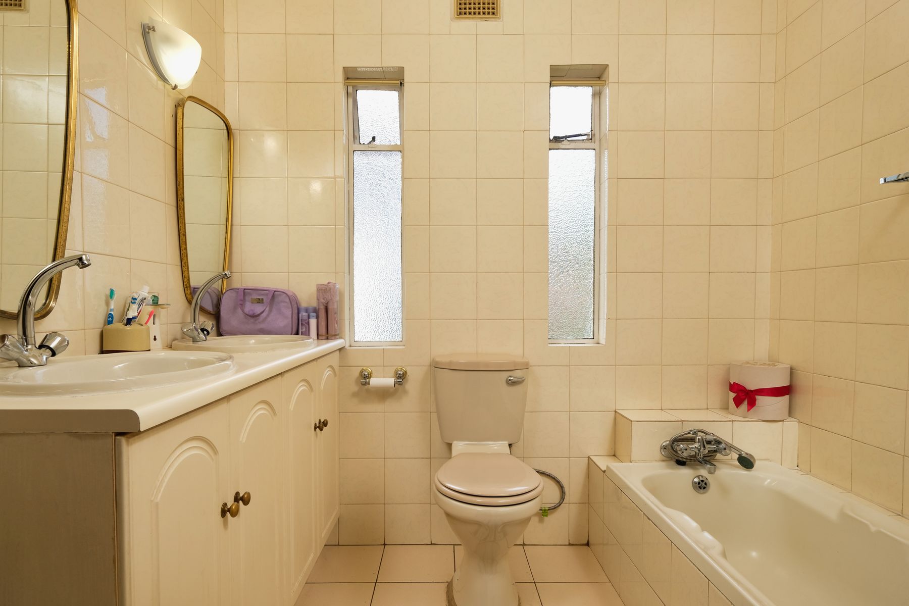 Double bathroom vanity with two sinks, framed cabinetry and coordinated mirrors
