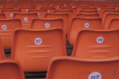 Orange seats in a stadium with numbers on them