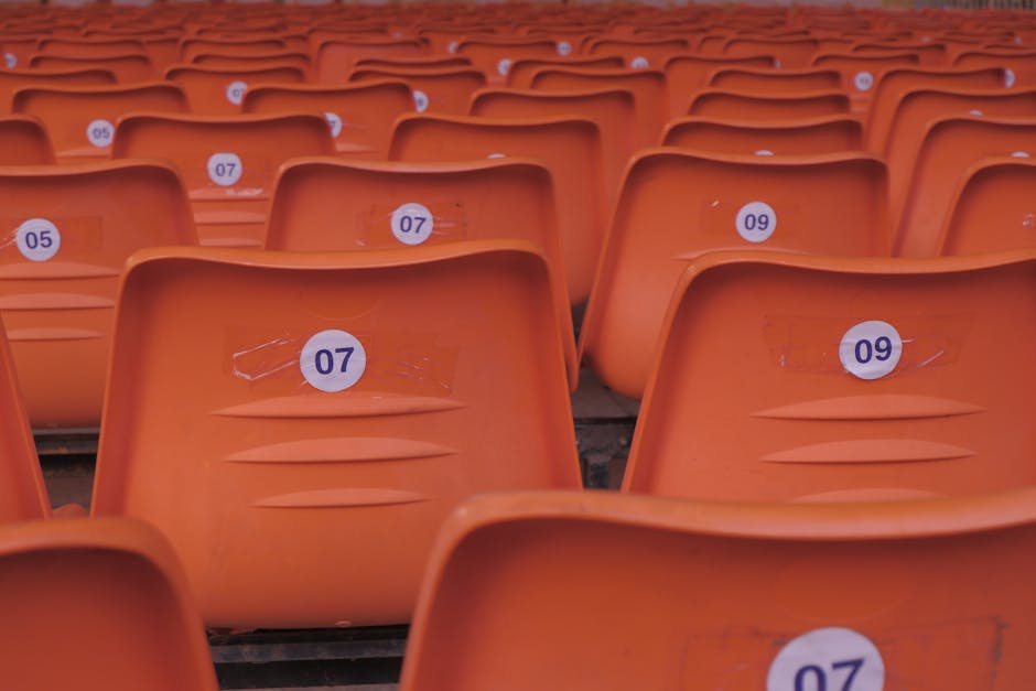 Como a Criatividade Pode Enriquecer Seus Relacionamentos 2 Rows of empty orange plastic stadium seats with visible numbered labels