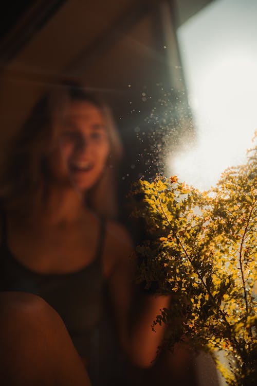 A woman is looking out the window at the sun