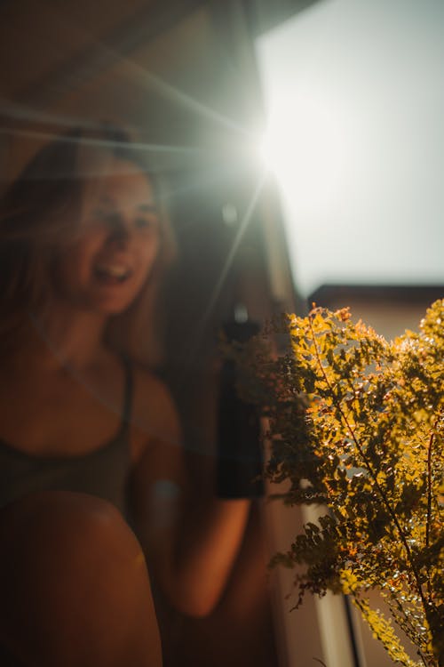 A woman is smiling while holding a flower