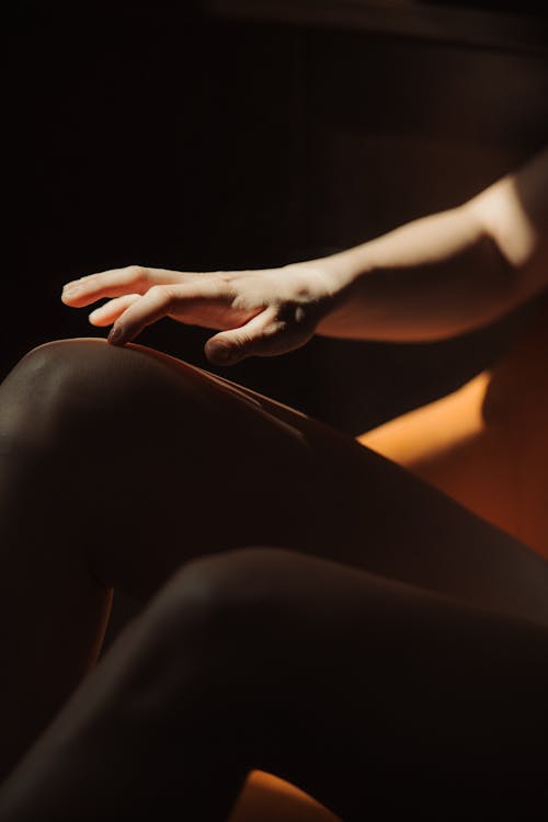 A woman's hand is on a chair in the dark