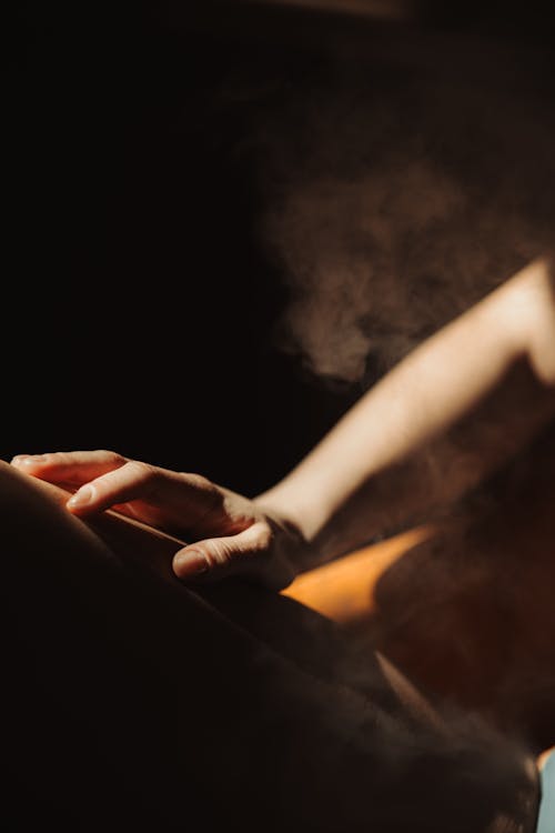 A woman is sitting on a chair with steam coming out of her hands