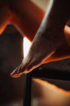 Artistic close-up of bare feet resting on a chair, showcasing softness and relaxation.